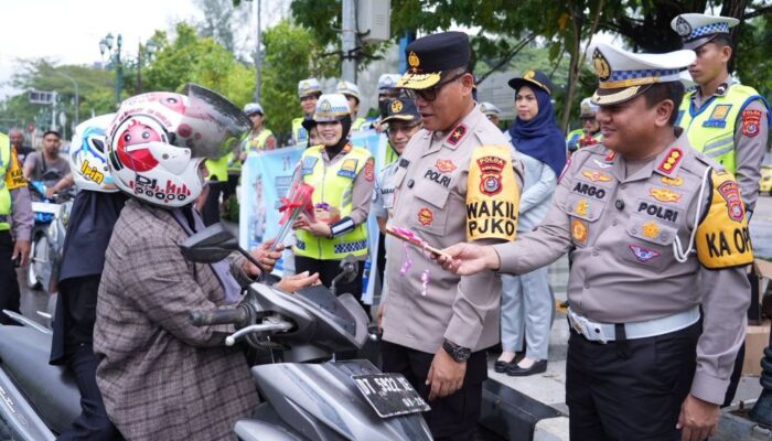 Cara Ditlantas Polda Sultra Edukasi Warga: Bagi Bunga dan Helm di Jalan Protokol Kendari